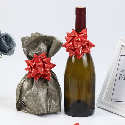 Étoile d'or présent ruban arc vin rouge cadeau emballage ruban arc